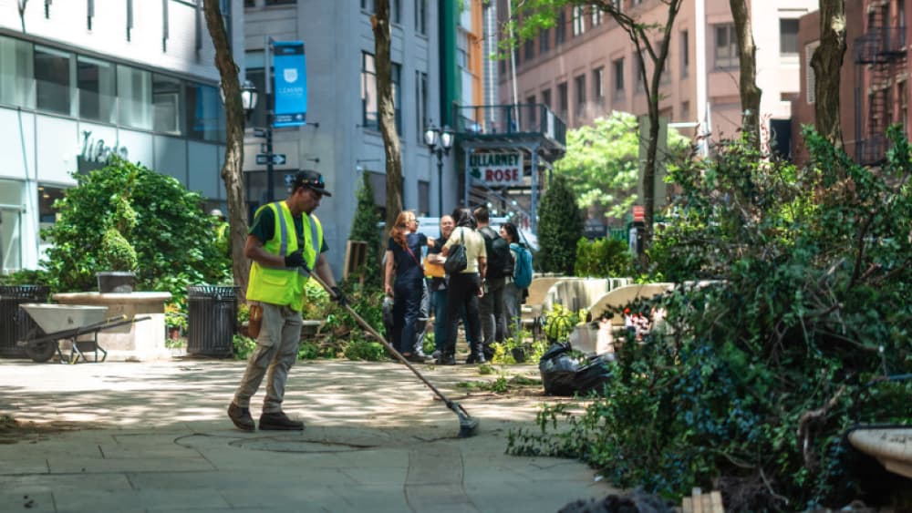 A worker sweeping the path during Landscaping Day