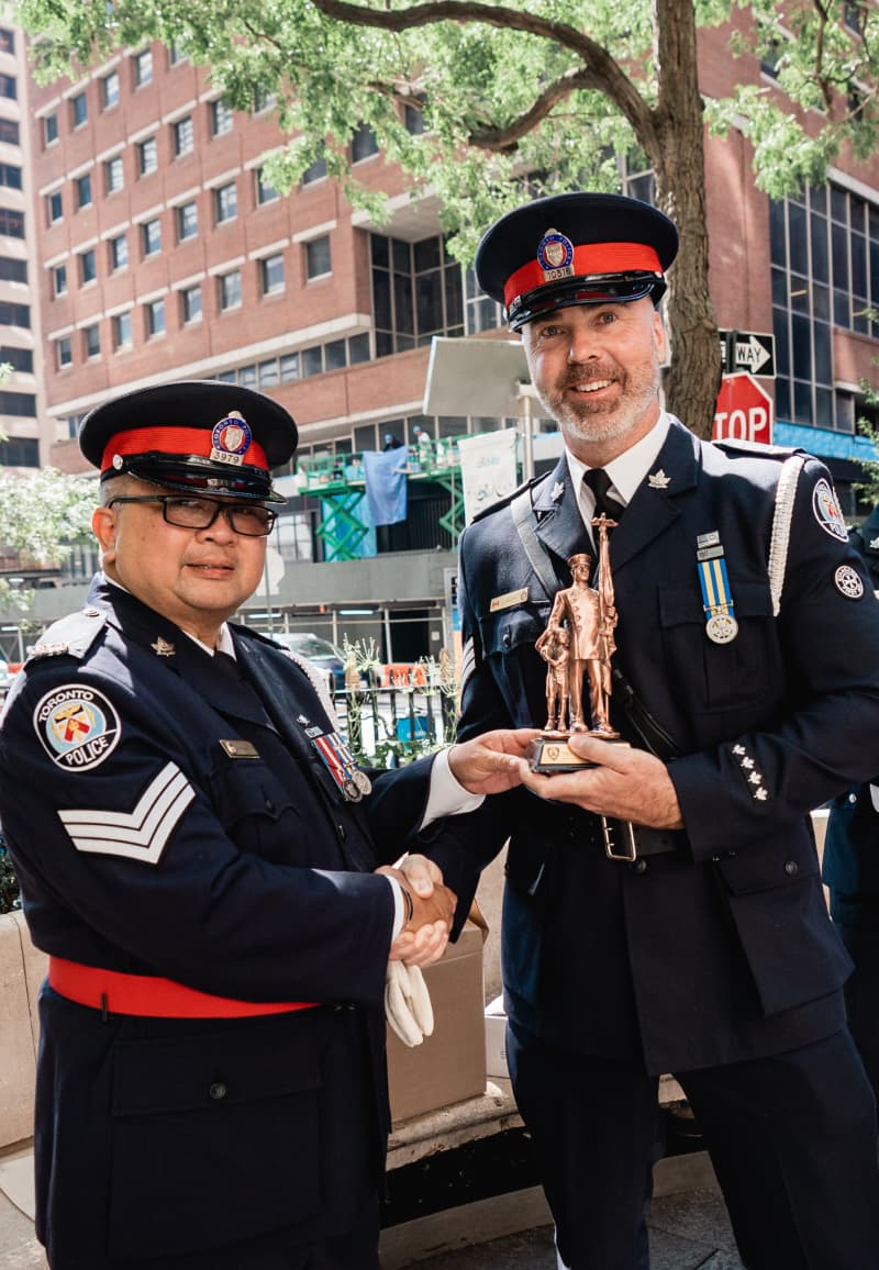 Toronto Police officers exchanging a commemorative gift